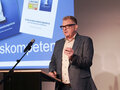 Hochschultag 2025 Keynote-Speaker Thilo Baum steht auf der Bühne an einem Rednerpult.