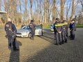 Internationaler Austausch Mehrere Polizisten stehen draußen bei Herbstwetter um ein Auto herum.