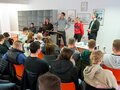 Veranstaltungsbericht Mehrere Referentinnen und Refrenten stehen auf einer Bühne vor dem Publikum.