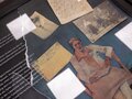 Veranstaltungsbericht Mehrere Ausstellungsstücke, die in einer Glasvitrine liegen.