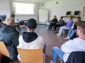 Veranstaltungsbericht Eine Referentin steht vor einem Stuhlkreis und redet mit den Teilnehmenden.