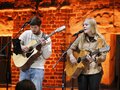 Ein junger Mann und eine junge Frau spielen Gitarre, die Frau singt dabei.