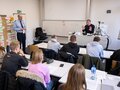 Veranstaltungsbericht Zwei Referenten diskutieren mit den Teilnehmenden des Workshops in einem vollen Seminarraum.
