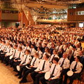 Graduierungsfeier Hagen 2025 In mehreren Stuhlreihen sitzen die Graduierten in einem großen Saal. Die Vorderen tragen Polizeiuniformen.