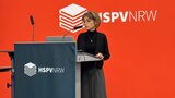 Esther Herfurth moderiert die Veranstaltung vom Rednerpult aus.